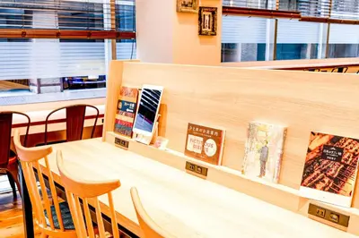 a restaurant with a table with chairs and books at Comfort Hotel Tokyo Kanda in Tokyo