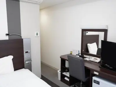 a bedroom with a desk with a bed and a mirror at Comfort Hotel Tokyo Kanda in Tokyo