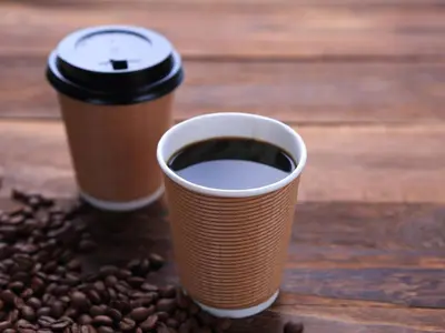 two cups of coffee sitting on a table with coffee beans at Comfort Hotel Tokyo Kiyosumi Shirakawa in Tokyo