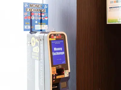 a money exchange machine is next to a wall at Comfort Hotel Tokyo Kiyosumi Shirakawa in Tokyo