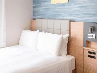 a bedroom with a white bed and a painting at Comfort Hotel Tokyo Kiyosumi Shirakawa in Tokyo