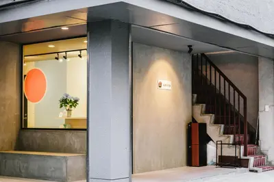 a store front with a staircase in the window at unito CHIYODA in Tokyo