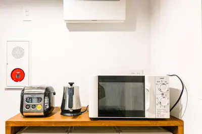 a microwave and a toaster on a wooden table at unito CHIYODA in Tokyo