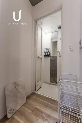 a bathroom with a walk in shower and a chair at unito CHIYODA in Tokyo