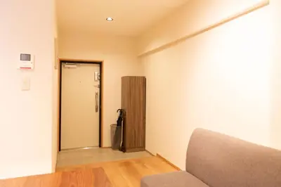 a living room with a door and a couch in a room at NIYS apartments 01 type in Tokyo