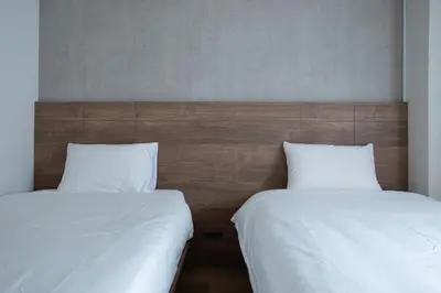 two beds sitting next to each other in a room at NIYS apartments 01 type in Tokyo