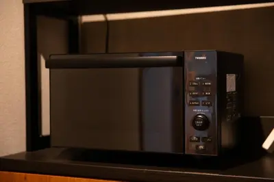 a microwave oven sitting on top of a counter at NIYS apartments 01 type in Tokyo