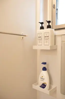 a bathroom with two shelves with soap and a mirror at NIYS apartments 01 type in Tokyo
