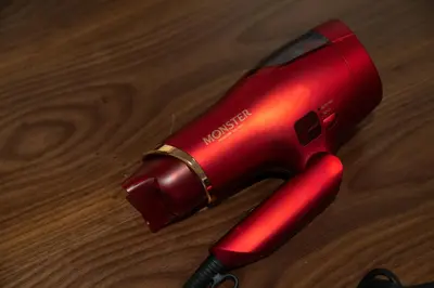 a red blow dryer sitting on top of a wooden table at NIYS apartments 01 type in Tokyo