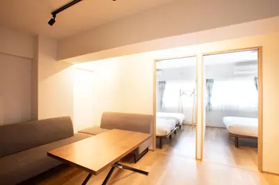 a room with a couch and a table with two beds at NIYS apartments 01 type in Tokyo