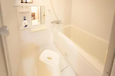 a white bathroom with a toilet and a bath tub at NIYS apartments 01 type in Tokyo