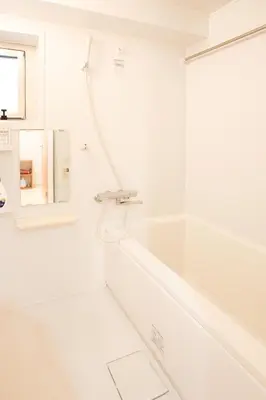 a white bathroom with a tub and a shower at NIYS apartments 01 type in Tokyo
