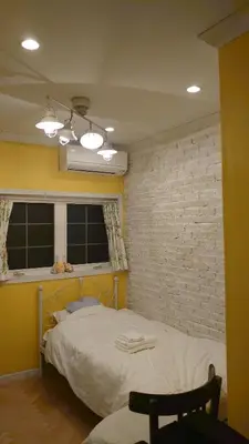 a bedroom with a bed and a brick wall at \u30db\u30c6\u30eb The Standard Apartment Shibuya D 2020\u5e74\u30aa\u30fc\u30d7\u30f3 in Tokyo