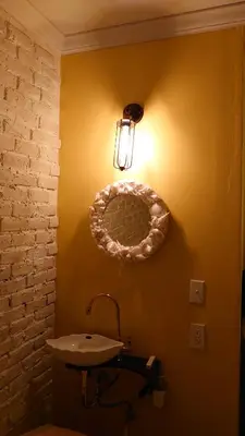 a bathroom with a sink and a light on the wall at \u30db\u30c6\u30eb The Standard Apartment Shibuya D 2020\u5e74\u30aa\u30fc\u30d7\u30f3 in Tokyo