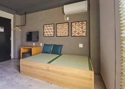 a bedroom with a wooden bed in a room at IKIDANE Residential Hotel Sumida Kyojima in Tokyo
