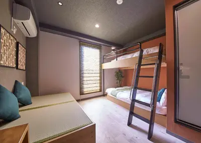 a bedroom with bunk beds and a desk and a ladder at IKIDANE Residential Hotel Sumida Kyojima in Tokyo