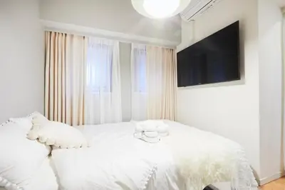 a white bedroom with a teddy bear on a bed at P OIN T - Shinjuku Kabukicho Designer's Apartment I in Tokyo