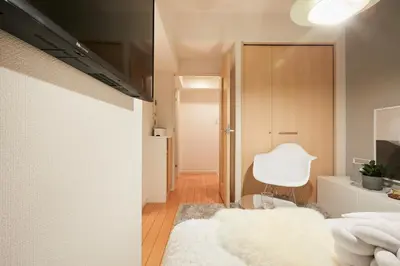 a bedroom with a white bed and a white chair at P OIN T - Shinjuku Kabukicho Designer's Apartment I in Tokyo