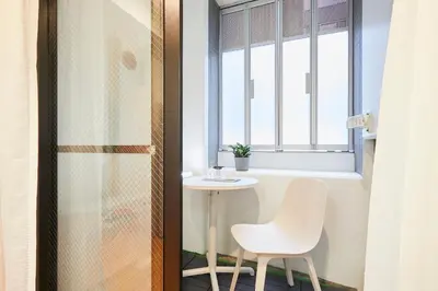 a small table and a chair in a room with a window at P OIN T - Shinjuku Kabukicho Designer's Apartment I in Tokyo