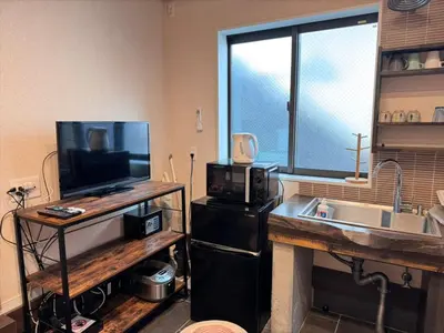 a kitchen with a sink and a counter with a microwave at YADOYA Ueno-Rikyu in Tokyo