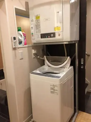 a washing machine in a kitchen with a microwave at YADOYA Ueno-Rikyu in Tokyo