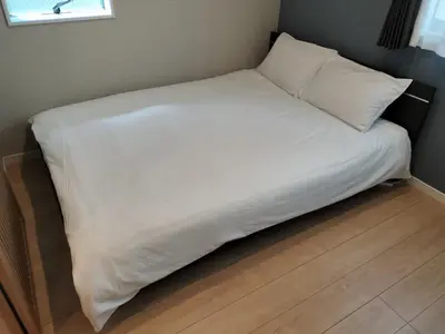 a bed with white sheets and pillows in a room at YADOYA Ueno-Rikyu in Tokyo