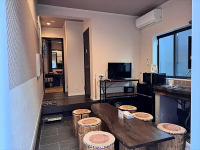 a room with a kitchen and a bunch of stools at YADOYA Ueno-Rikyu in Tokyo
