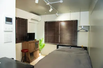 a bedroom with a bed and a tv and some windows at H.W.HILLS.103 in Tokyo
