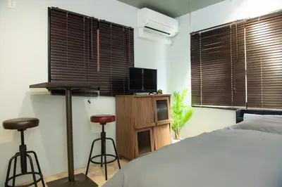 a bedroom with a bed and two bar stools at H.W.HILLS.103 in Tokyo