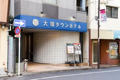 a building with a blue sign on the side of it at Otsuka Town Hotel in Tokyo