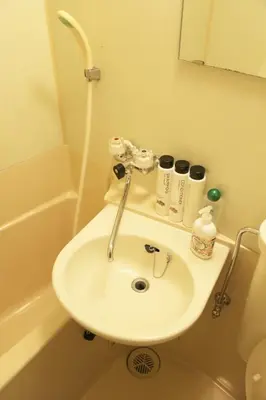 a white sink in a bathroom with a shower at Lions Mansion Dogenzaka 207 in Tokyo