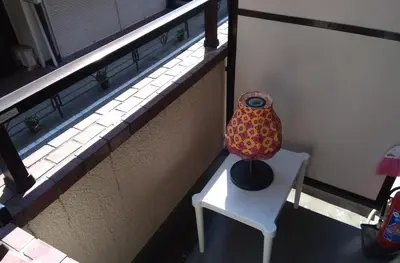 a vase sitting on a white chair next to a building at Lions Mansion Dogenzaka 207 in Tokyo