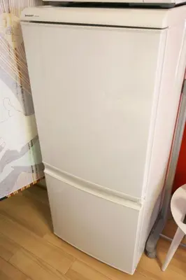 a white refrigerator freezer sitting next to a wooden floor at Lions Mansion Dogenzaka 207 in Tokyo