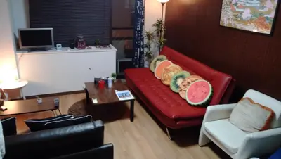 a living room with a red couch with fruit on it at Lions Mansion Dogenzaka 207 in Tokyo