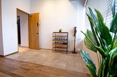 a room with a potted plant and a shelf of wine bottles at American Vintage Suite in Tokyo