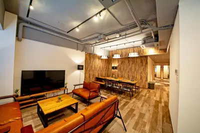 a living room with a couch and a television and tables at American Vintage Suite in Tokyo