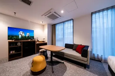 a living room with a couch and a table and a tv at Bay Hotel Tokyo Hamamatsucho in Tokyo