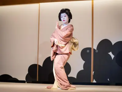 a woman in a pink kimono standing on a stage at Asakusa View Hotel Annex Rokku in Tokyo