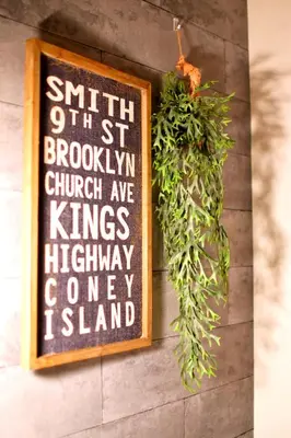 a sign hanging on a wall with a plant at Tune Inn Tokyo Bay in Tokyo