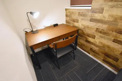 a wooden desk with a lamp and a wooden accent wall at Tune Inn Tokyo Bay in Tokyo