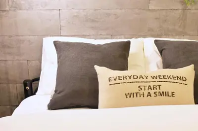 a bed with a pillow with a sign on it at Tune Inn Tokyo Bay in Tokyo