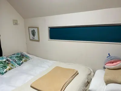 a bedroom with a bed with a window and a blanket at Naotoko Minpaku #HG1 \u9996\u90fd\u9ad8\u5165\u53e3\u8fc45\u5206 \u5e83\u300594\u5e73\u7c73 \u4e00\u6238\u5efa\u3066\u8cb8\u5207 \u9ad8\u901fWi-Fi \u7121\u6599\u99d0\u8eca\u5834\u4ed8 in Tokyo