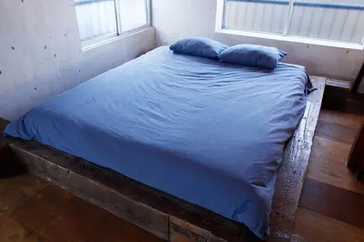 a bed with blue sheets and two pillows on it at \uff35\uff27\uff2f in Tokyo