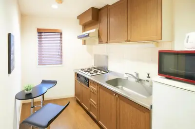 a small kitchen with a sink and a stove at S'CASA NishiShinjuku in Tokyo