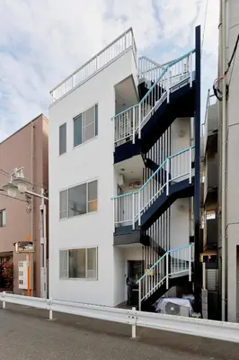 a white building with blue balconies on the side of it at Terrace Terano#101 in Tokyo