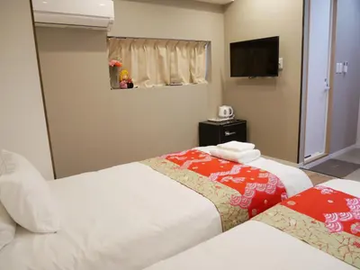 a hotel room with two beds and a television at Tokyo shinjukutei Hotel Asahi gruop \u6771\u4eac\u65b0\u5bbf\u4ead\u30db\u30c6\u30eb in Tokyo