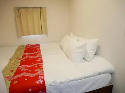 a bed with white sheets and pillows in a room at Tokyo shinjukutei Hotel Asahi gruop \u6771\u4eac\u65b0\u5bbf\u4ead\u30db\u30c6\u30eb in Tokyo