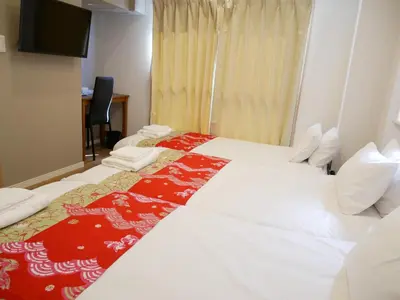 a hotel room with two beds and a television at Tokyo shinjukutei Hotel Asahi gruop \u6771\u4eac\u65b0\u5bbf\u4ead\u30db\u30c6\u30eb in Tokyo