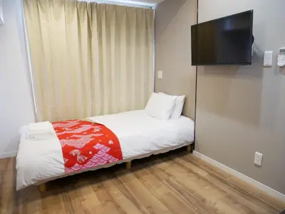 a small bedroom with a bed and a flat screen tv at Tokyo shinjukutei Hotel Asahi gruop \u6771\u4eac\u65b0\u5bbf\u4ead\u30db\u30c6\u30eb in Tokyo