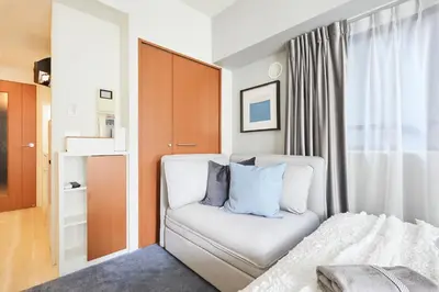 a bedroom with a white bed with blue pillows at P OIN T - Shinjuku Kabukicho Designer's Apartment II in Tokyo